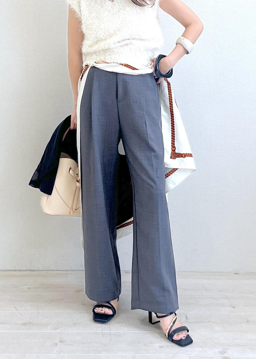 ベージュ系のショルダーバッグ、ブラック系のサンダル、ブラック系のテーラードジャケットを着用したレディースの夏コーディネートの7枚目の写真