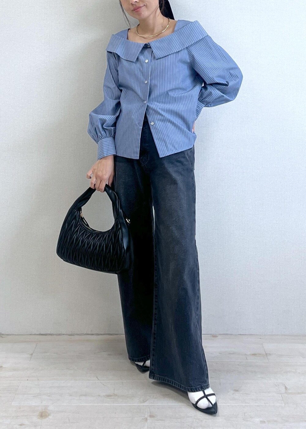 ブルー系のシャツ/ブラウス、グレー系のデニムパンツ、ブラック系のハンドバッグを着用したレディースの秋コーディネートの5枚目の写真