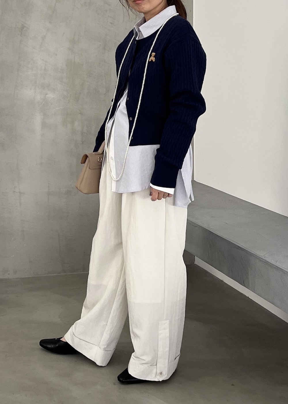 ベージュ系のショルダーバッグ、ブラック系のパンプス、ホワイト系のその他パンツを着用したレディースの冬コーディネートの3枚目の写真