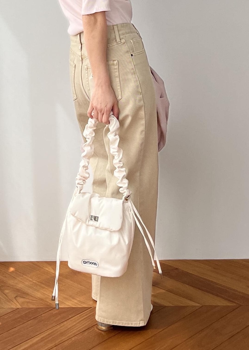 ホワイト系のショルダーバッグ、ピンク系のテーラードジャケット、ベージュ系のデニムパンツを着用したレディースの春コーディネートの10枚目の写真