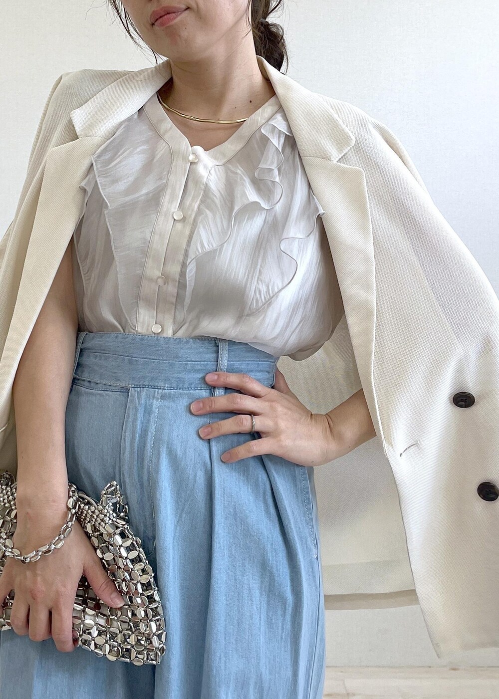 ホワイト系のサンダル、シルバー系のハンドバッグ、ブルー系のデニムパンツを着用したレディースの夏コーディネートの10枚目の写真