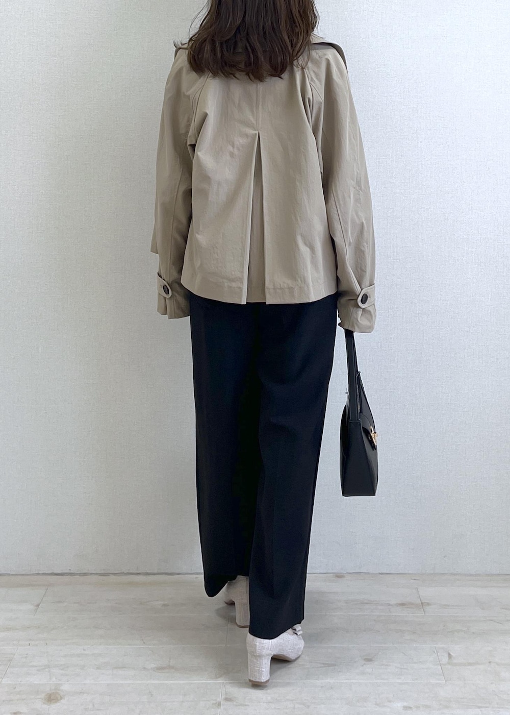 ブラック系のショルダーバッグ、ベージュ系のパンプス、ベージュ系のトレンチコートを着用したレディースの春コーディネートの4枚目の写真