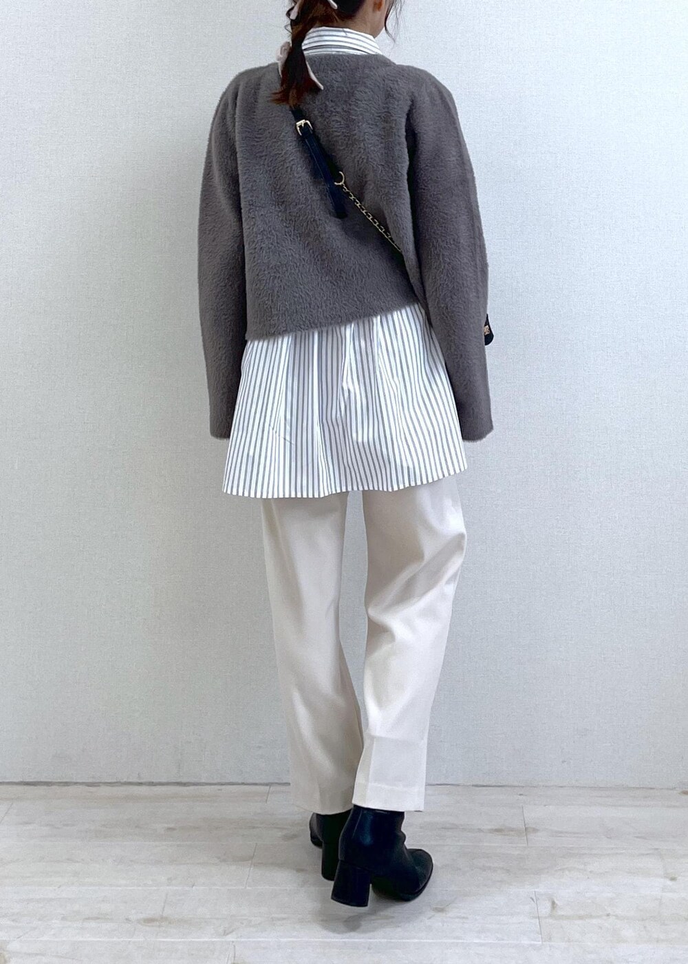 ブラック系のブーツ、ホワイト系のシャツ/ブラウス、ブラウン系のカーディガン/ボレロを着用したレディースの冬コーディネートの4枚目の写真