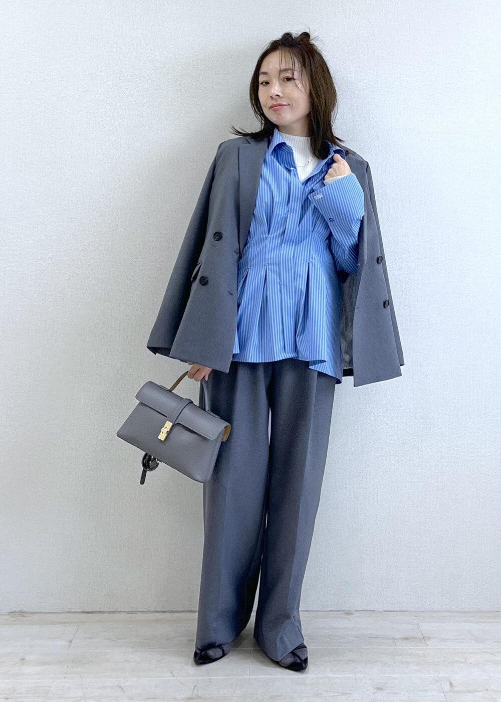 グレー系のショルダーバッグ、ブルー系のシャツ/ブラウス、ホワイト系のニット/セーターを着用したレディースの秋コーディネートの10枚目の写真