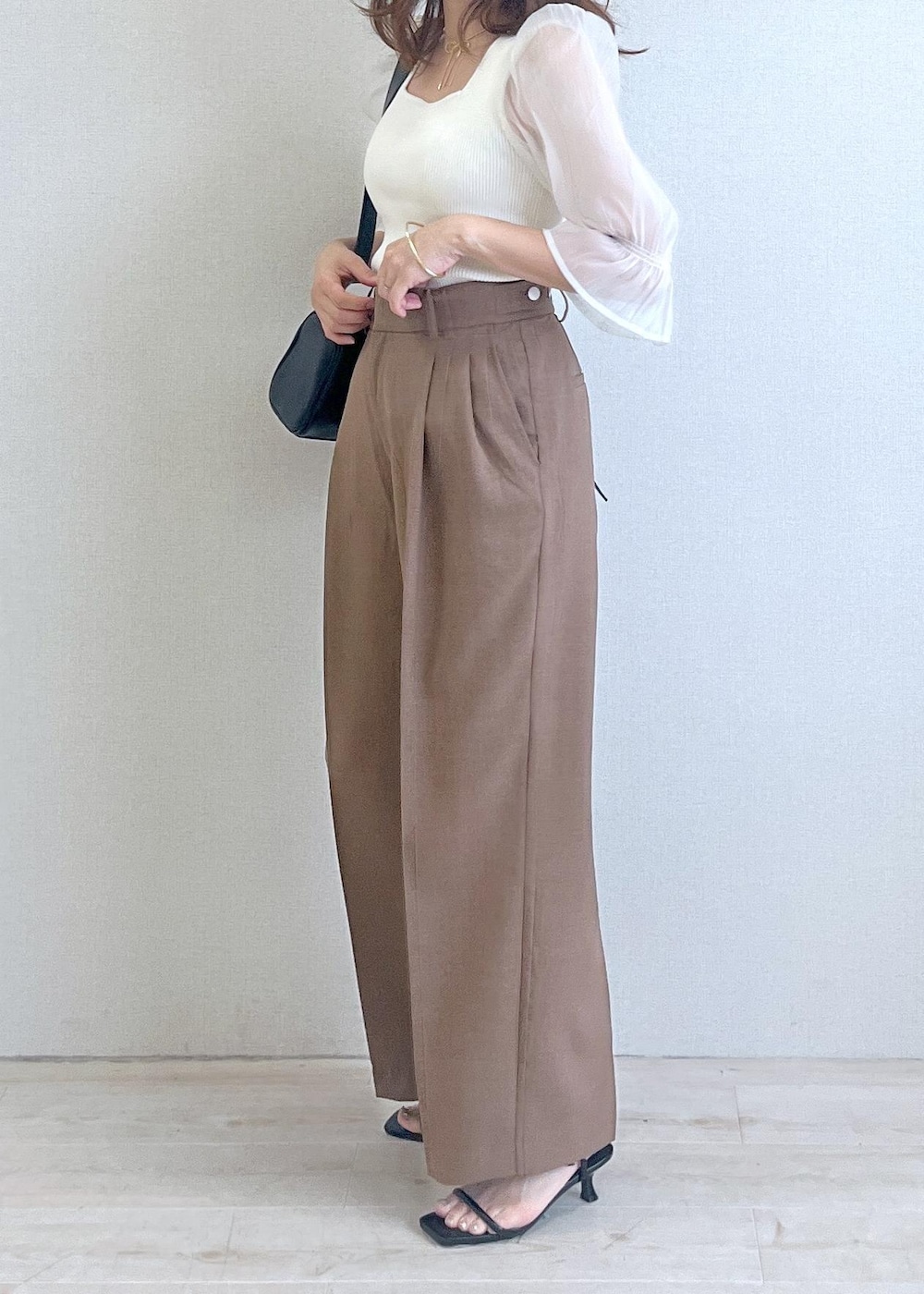 ブラック系のショルダーバッグ、ブラック系のサンダル、ブラウン系のテーラードジャケットを着用したレディースの夏コーディネートの3枚目の写真