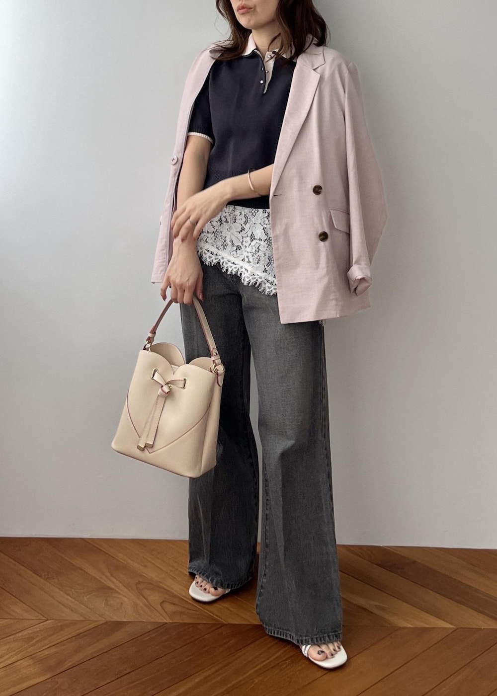 ベージュ系のショルダーバッグ、ピンク系のテーラードジャケット、グレー系のポロシャツを着用したレディースの春コーディネートの8枚目の写真