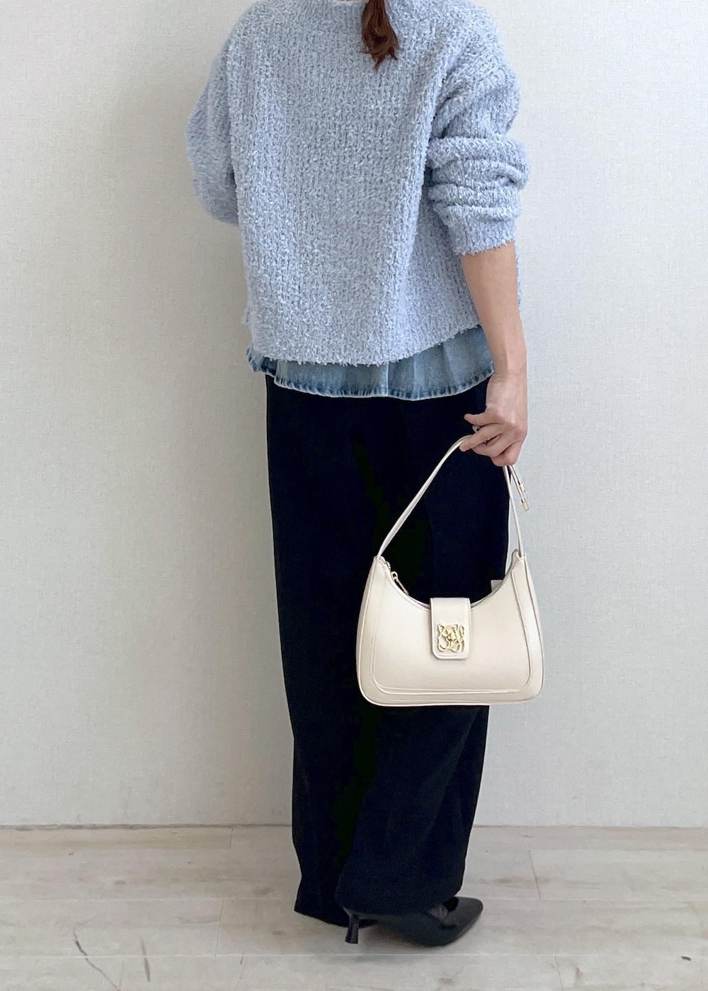 ホワイト系のハンドバッグ、ブルー系のカーディガン/ボレロ、ブラック系のサロペット/オーバーオールを着用したレディースの春コーディネートの4枚目の写真