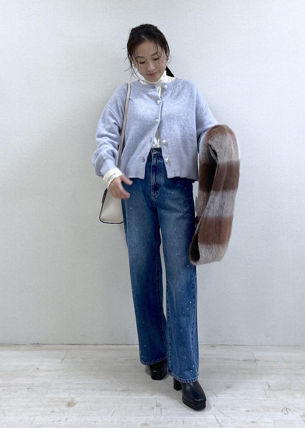 パープル系のカーディガン/ボレロ、ホワイト系のTシャツ/カットソー、ブラック系のブーツを着用したレディースの秋コーディネートの6枚目の写真