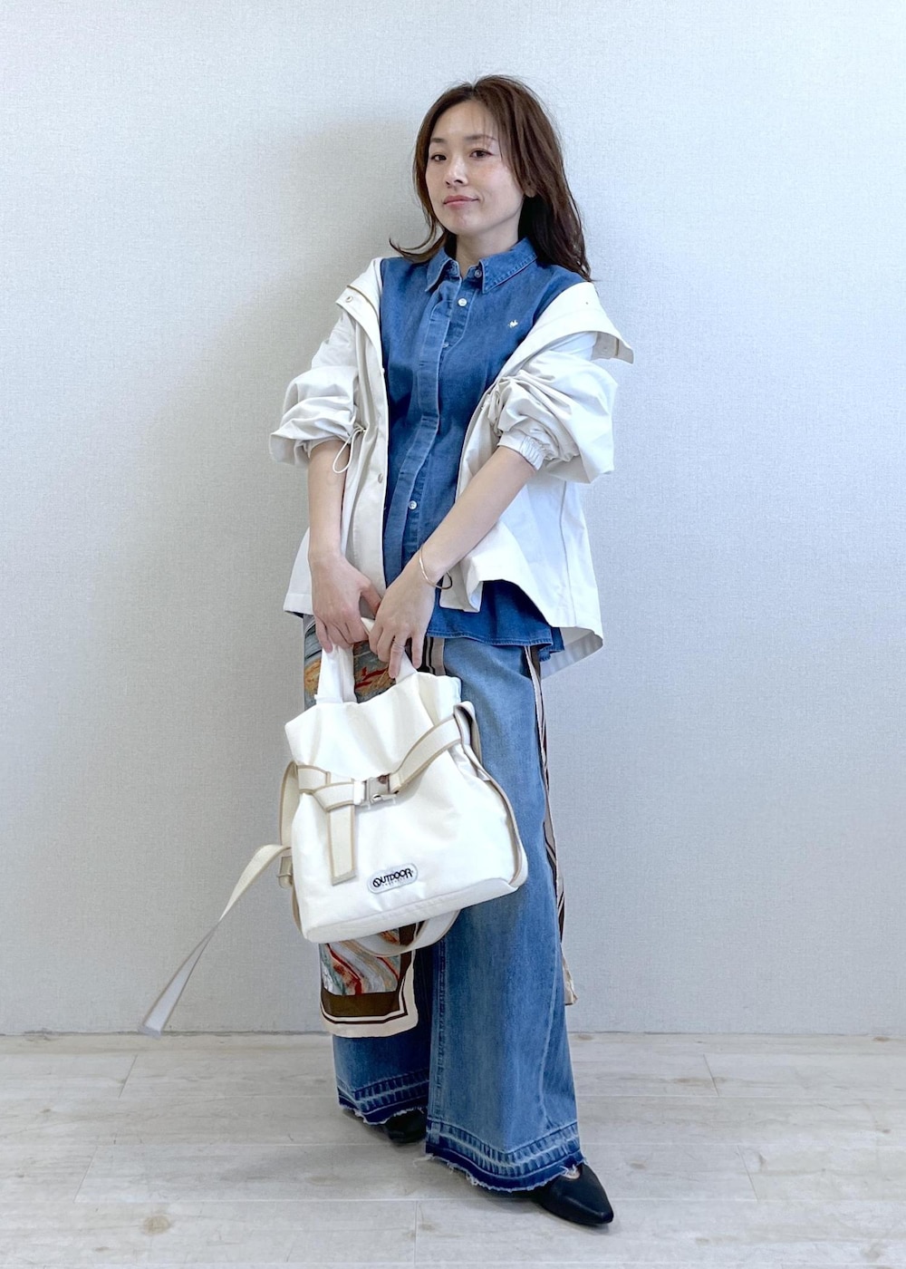 ブラック系のパンプス、ホワイト系のトートバッグ、ホワイト系のナイロンジャケットを着用したレディースの春コーディネートの6枚目の写真