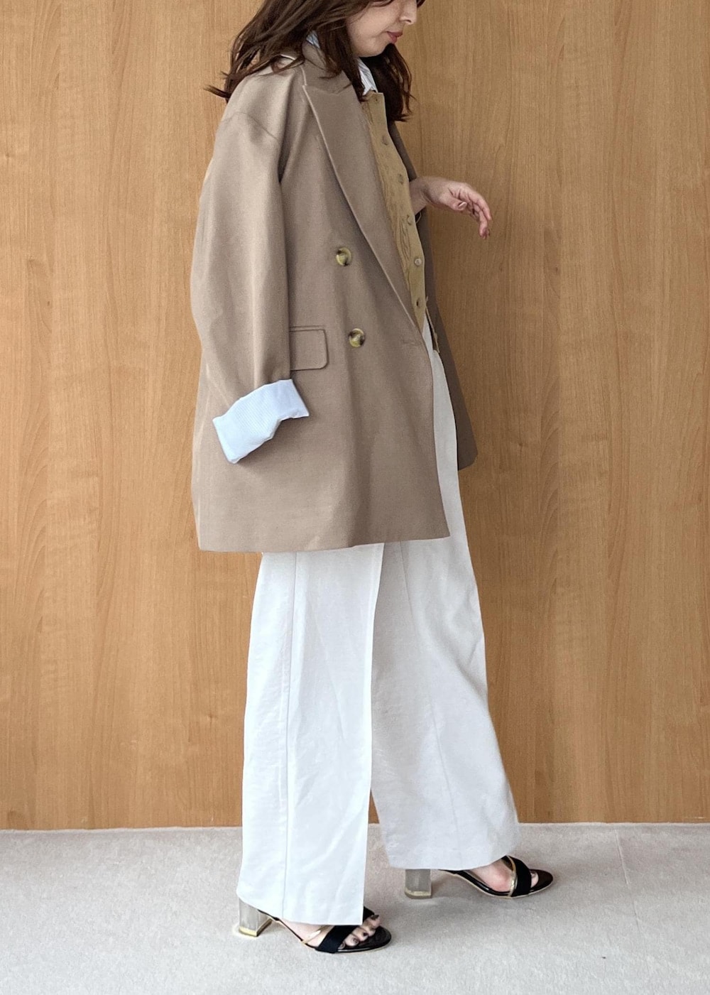 ブラック系のショルダーバッグ、イエロー系のテーラードジャケット、ホワイト系のその他パンツを着用したレディースの春コーディネートの4枚目の写真