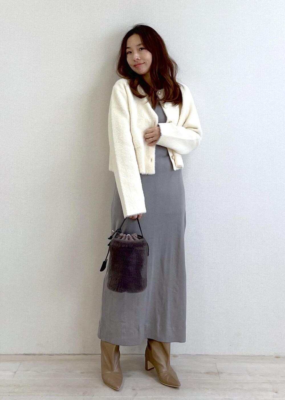 ベージュ系のブーツ、グレー系のショルダーバッグ、ホワイト系のカーディガン/ボレロを着用したレディースの冬コーディネートの6枚目の写真