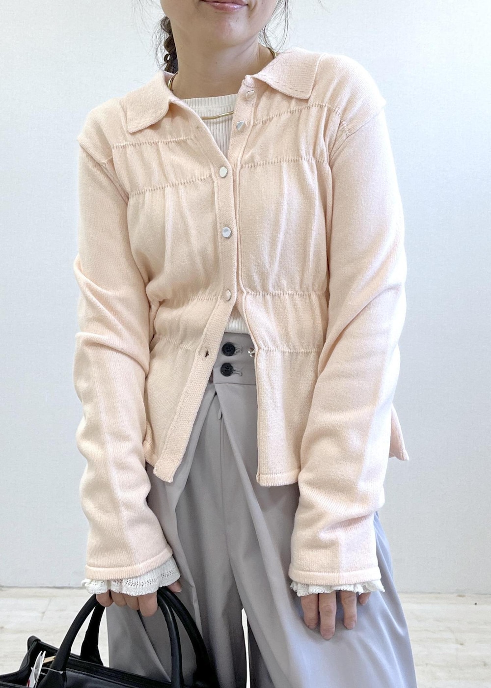 ホワイト系のニット/セーター、ピンク系のカーディガン/ボレロ、グレー系のその他パンツを着用したレディースの冬コーディネートの6枚目の写真