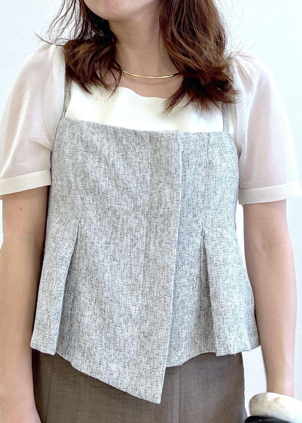 ブラック系のサンダル、ホワイト系のハンドバッグ、グリーン系のスカートを着用したレディースの春コーディネートの5枚目の写真