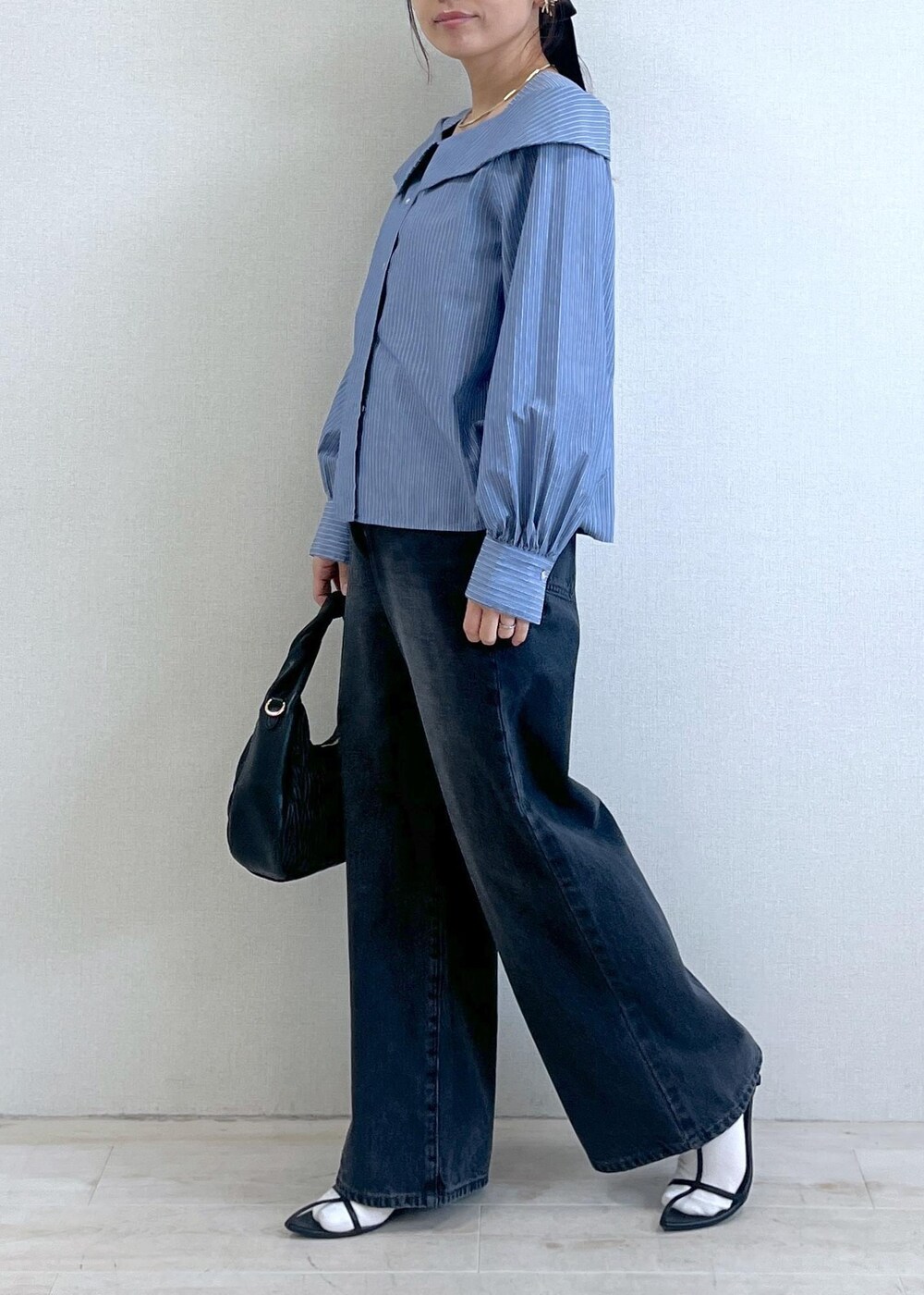 ブルー系のシャツ/ブラウス、グレー系のデニムパンツ、ブラック系のハンドバッグを着用したレディースの秋コーディネートの7枚目の写真