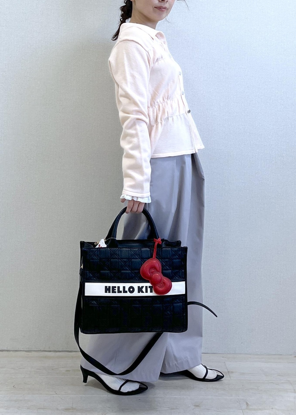 ホワイト系のニット/セーター、ピンク系のカーディガン/ボレロ、グレー系のその他パンツを着用したレディースの冬コーディネートの4枚目の写真