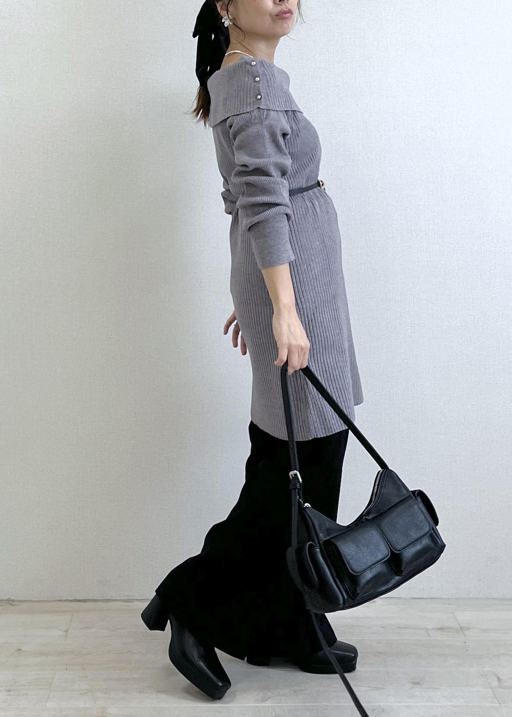 ブラック系のスラックス、ブラック系のショルダーバッグ、ブラック系のブーツを着用したレディースの秋コーディネートの5枚目の写真