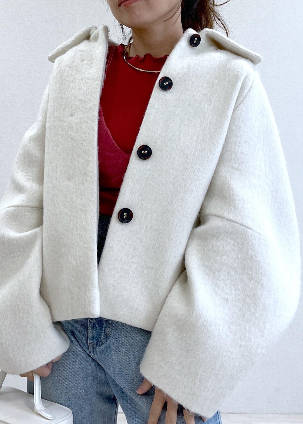 ベージュ系のブーツ、ホワイト系のその他アウター、ブルー系のデニムパンツを着用したレディースの秋コーディネートの5枚目の写真