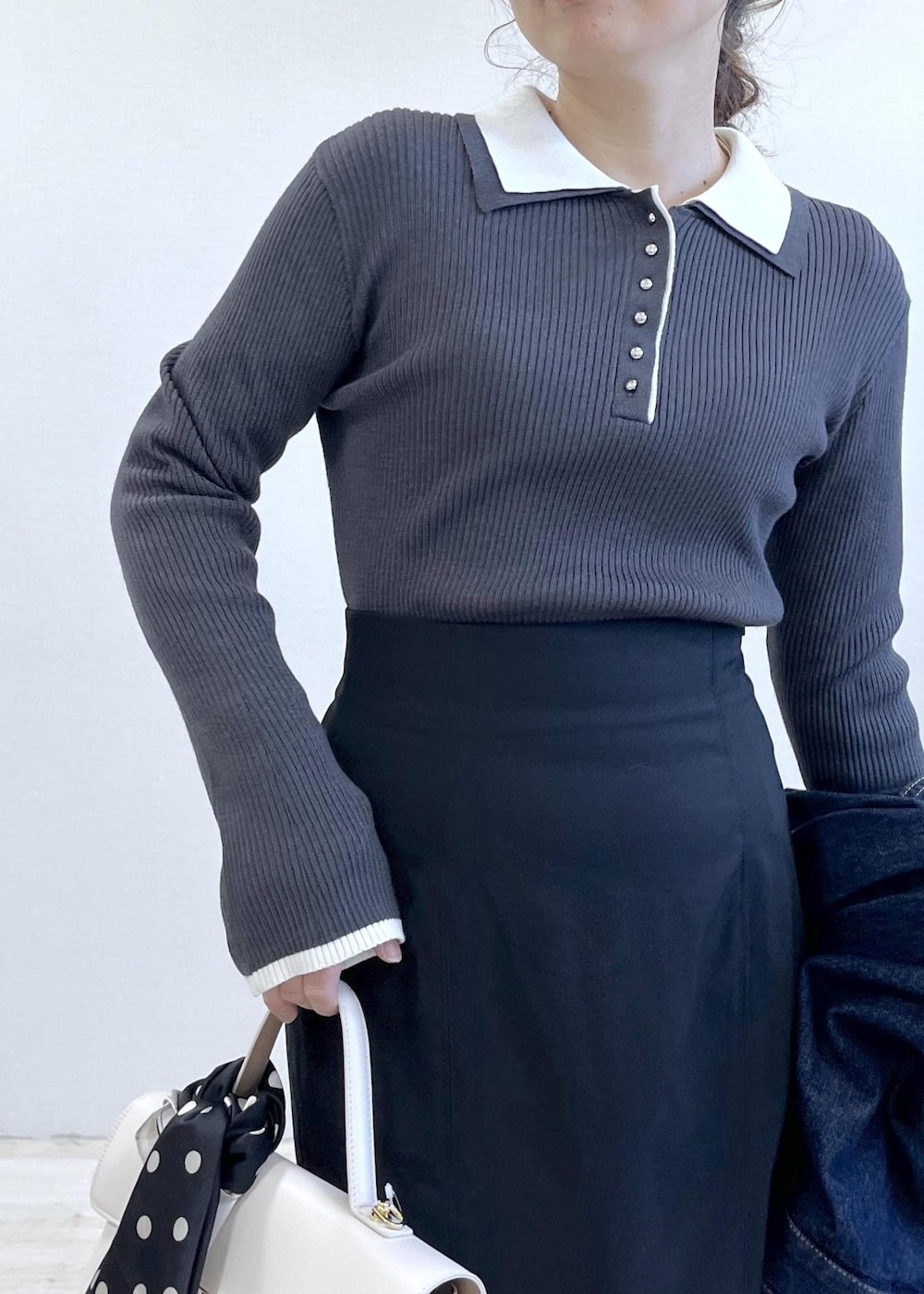 ブルー系のデニムジャケット、ブラック系のスカート、グレー系のニット/セーターを着用したレディースの冬コーディネートの8枚目の写真