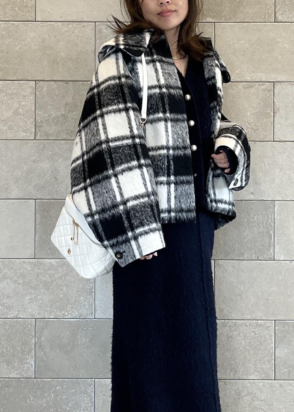 ブラック系のブーツ、ホワイト系のハンドバッグ、ブルー系のスカートを着用したレディースの秋コーディネートの5枚目の写真