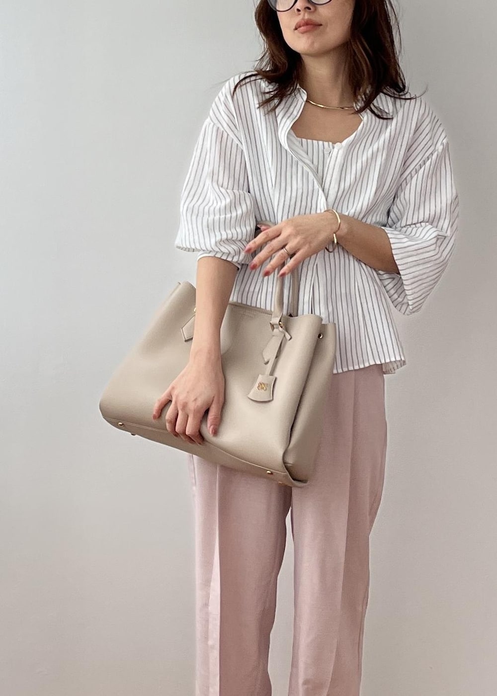 ピンク系のその他パンツ、ベージュ系のトートバッグ、ホワイト系のシャツ/ブラウスを着用したレディースの春コーディネートの2枚目の写真