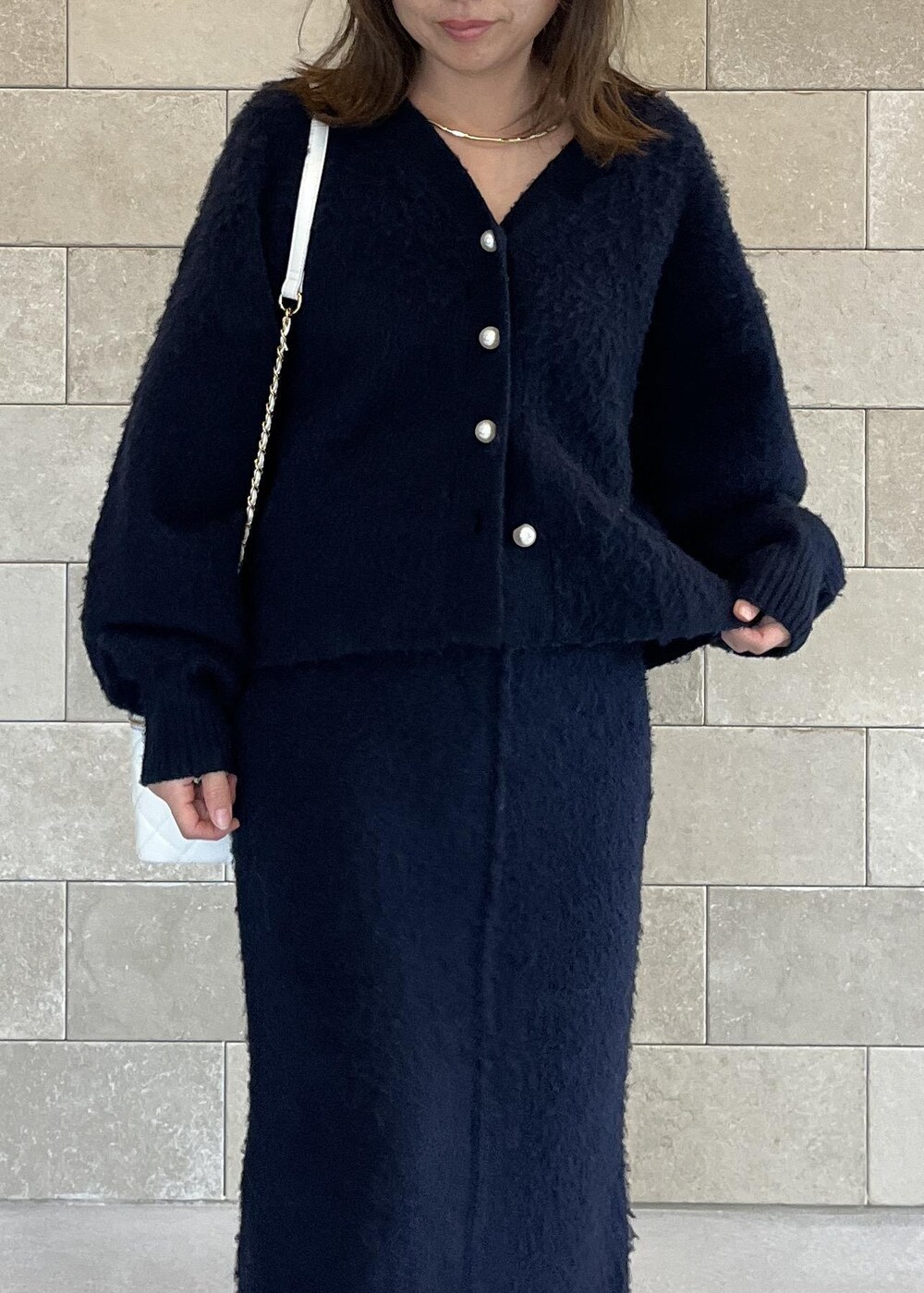 ブラック系のブーツ、ホワイト系のハンドバッグ、ブルー系のスカートを着用したレディースの秋コーディネートの10枚目の写真