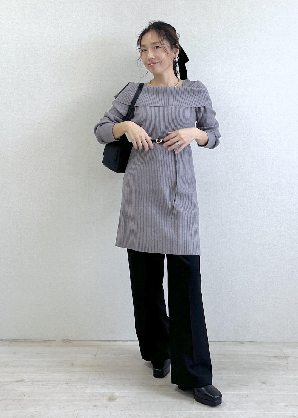 ブラック系のスラックス、ブラック系のショルダーバッグ、ブラック系のブーツを着用したレディースの秋コーディネートの10枚目の写真