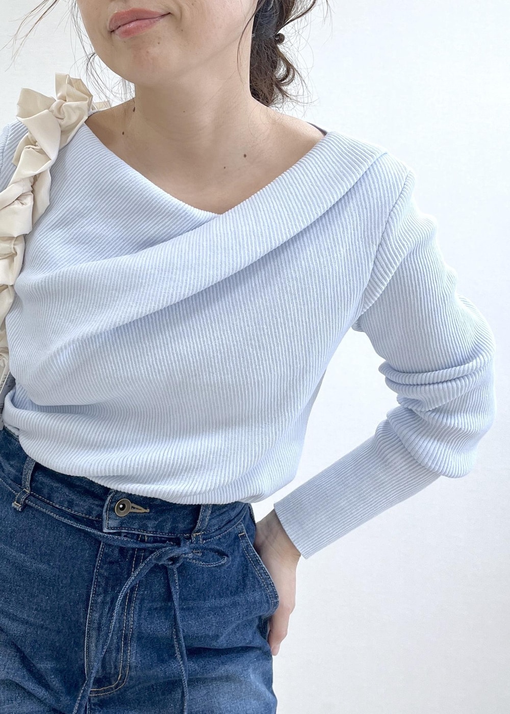 ブルー系のテーラードジャケット、ブルー系のデニムパンツ、ホワイト系のショルダーバッグを着用したレディースの冬コーディネートの8枚目の写真