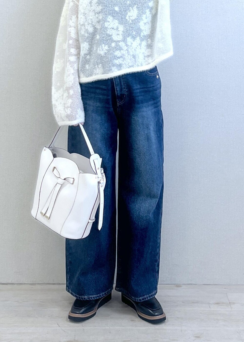 ブラック系のローファー、ホワイト系のニット/セーター、ブルー系のデニムパンツを着用したレディースの秋コーディネートの2枚目の写真