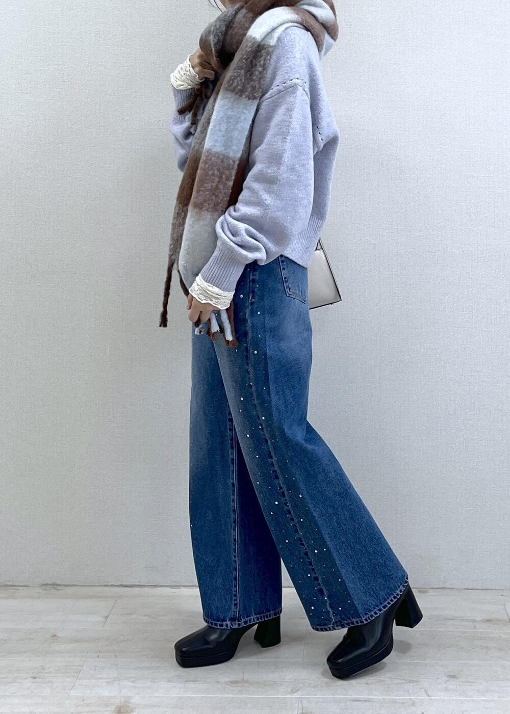 パープル系のカーディガン/ボレロ、ホワイト系のTシャツ/カットソー、ブラック系のブーツを着用したレディースの秋コーディネートの2枚目の写真