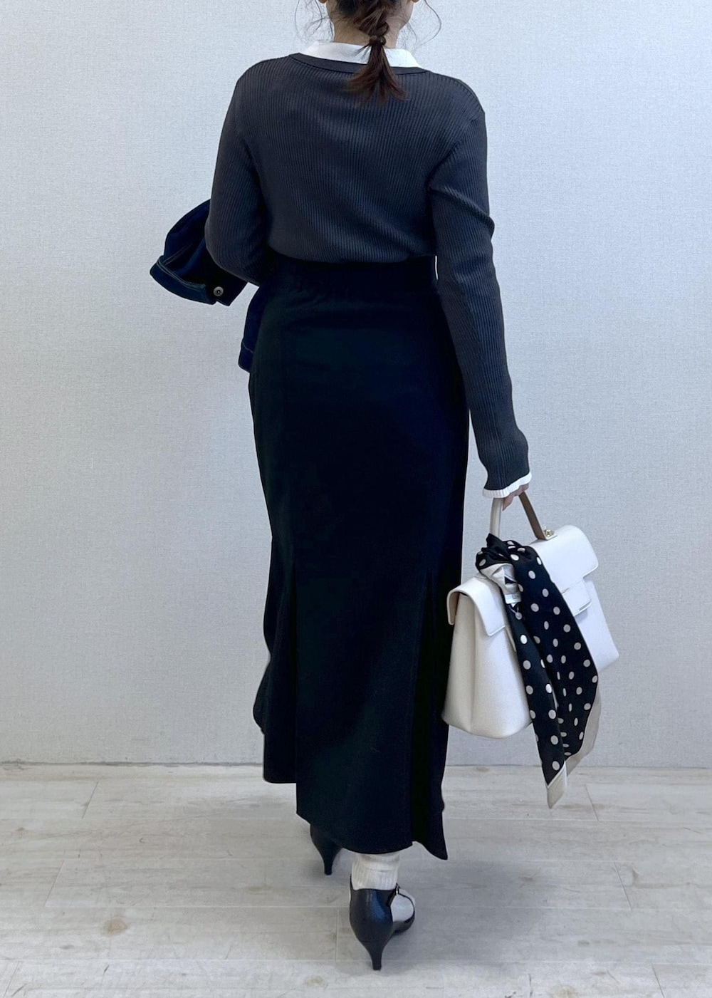 ブルー系のデニムジャケット、ブラック系のスカート、グレー系のニット/セーターを着用したレディースの冬コーディネートの9枚目の写真