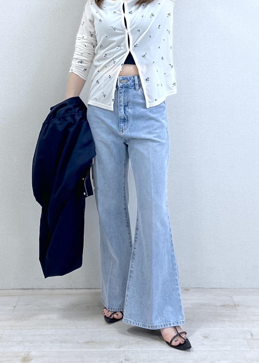 ベージュ系のショルダーバッグ、ブルー系のナイロンジャケット、ブラック系のキャミソールを着用したレディースの春コーディネートの8枚目の写真