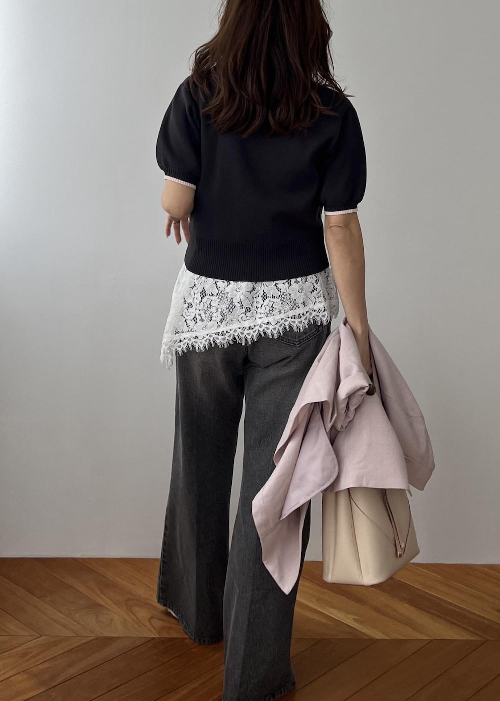 ベージュ系のショルダーバッグ、ピンク系のテーラードジャケット、グレー系のポロシャツを着用したレディースの春コーディネートの4枚目の写真