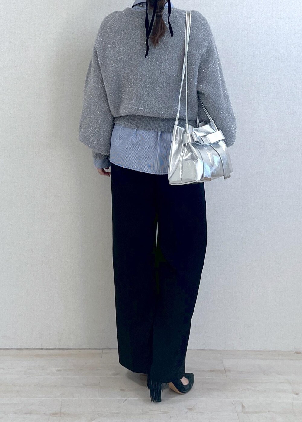 シルバー系のショルダーバッグ、ブラック系のスラックス、ブルー系のシャツ/ブラウスを着用したレディースの冬コーディネートの5枚目の写真