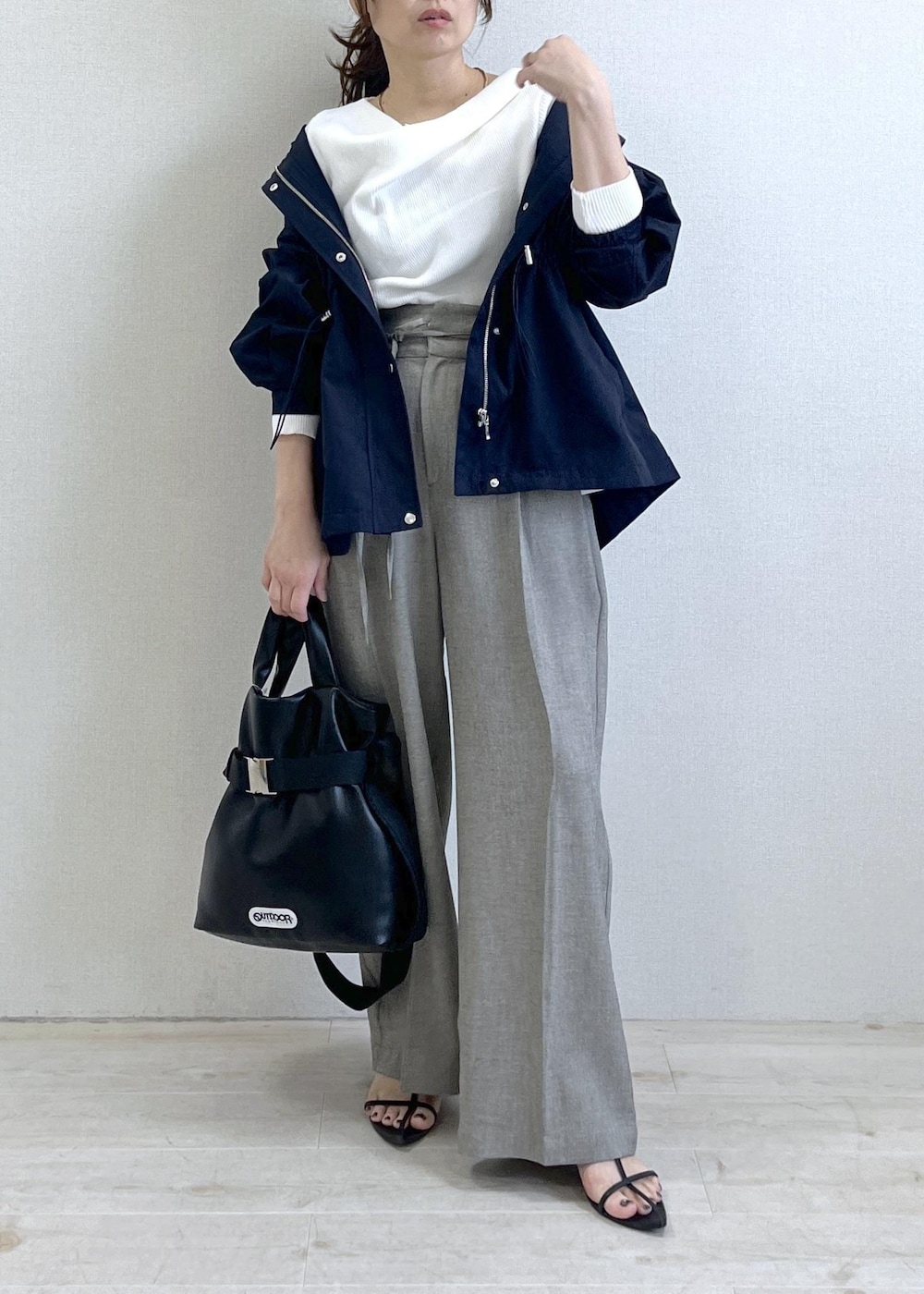 ブラック系のトートバッグ、ブルー系のナイロンジャケット、グレー系のその他パンツを着用したレディースの春コーディネートの2枚目の写真