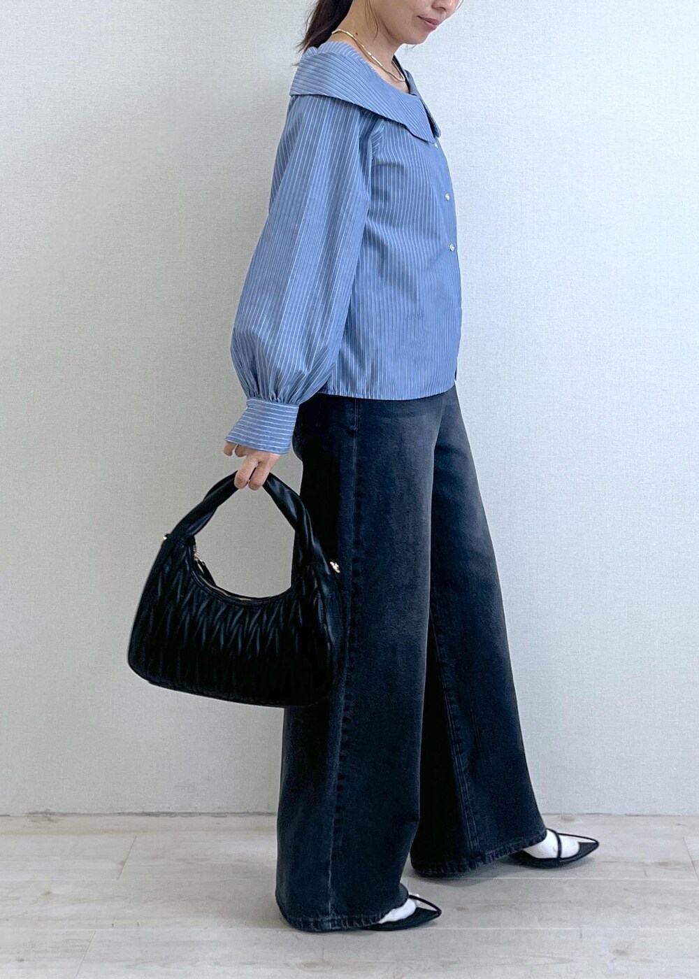 ブルー系のシャツ/ブラウス、グレー系のデニムパンツ、ブラック系のハンドバッグを着用したレディースの秋コーディネートの6枚目の写真