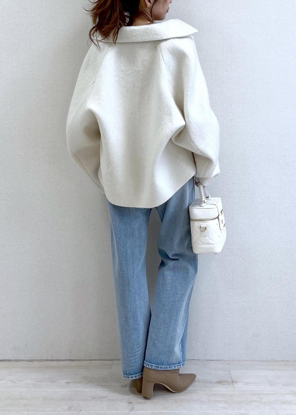 ベージュ系のブーツ、ホワイト系のその他アウター、ブルー系のデニムパンツを着用したレディースの秋コーディネートの4枚目の写真