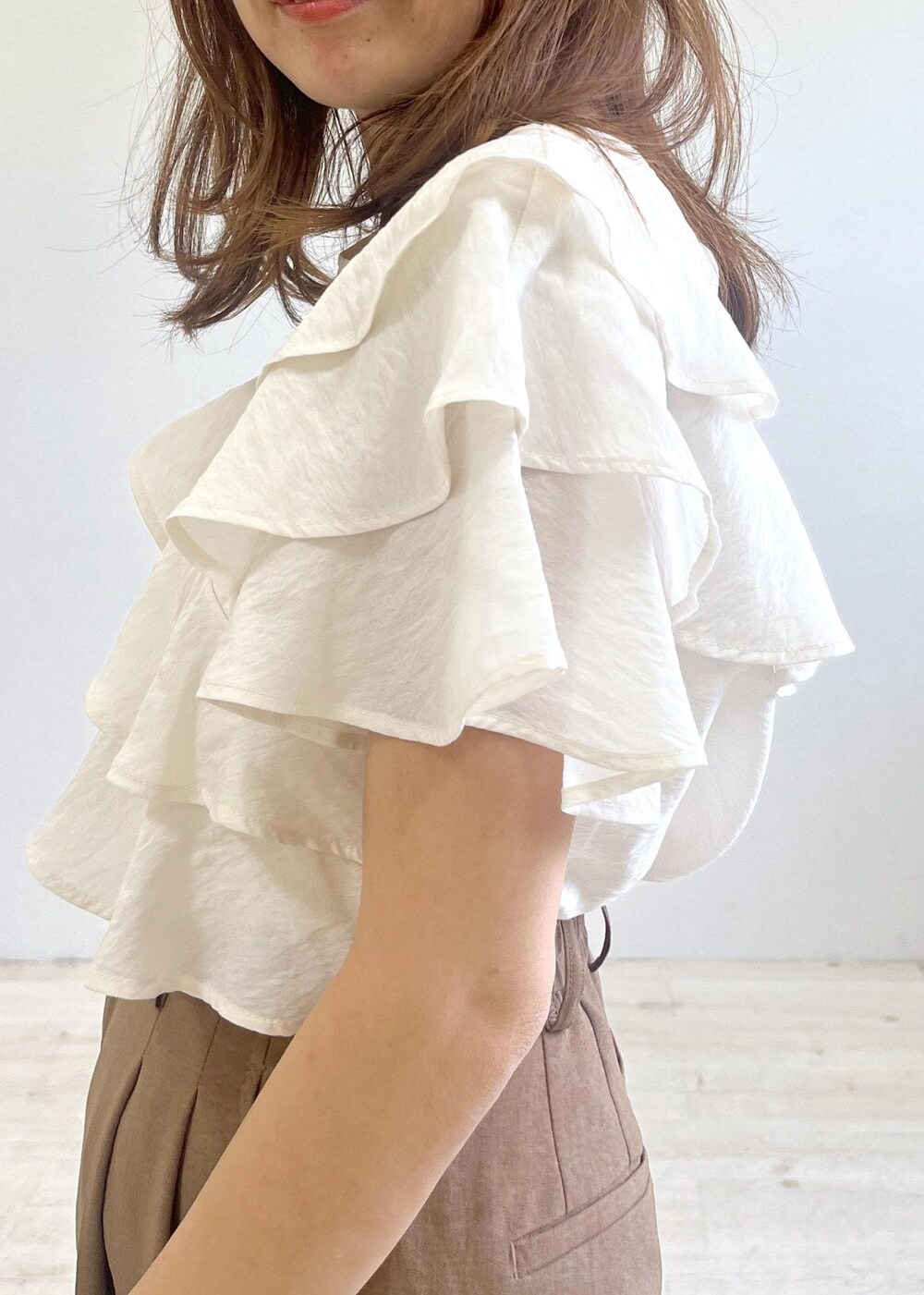 ブラック系のショルダーバッグ、ブラック系のサンダル、ブラウン系のスラックスを着用したレディースの夏コーディネートの5枚目の写真