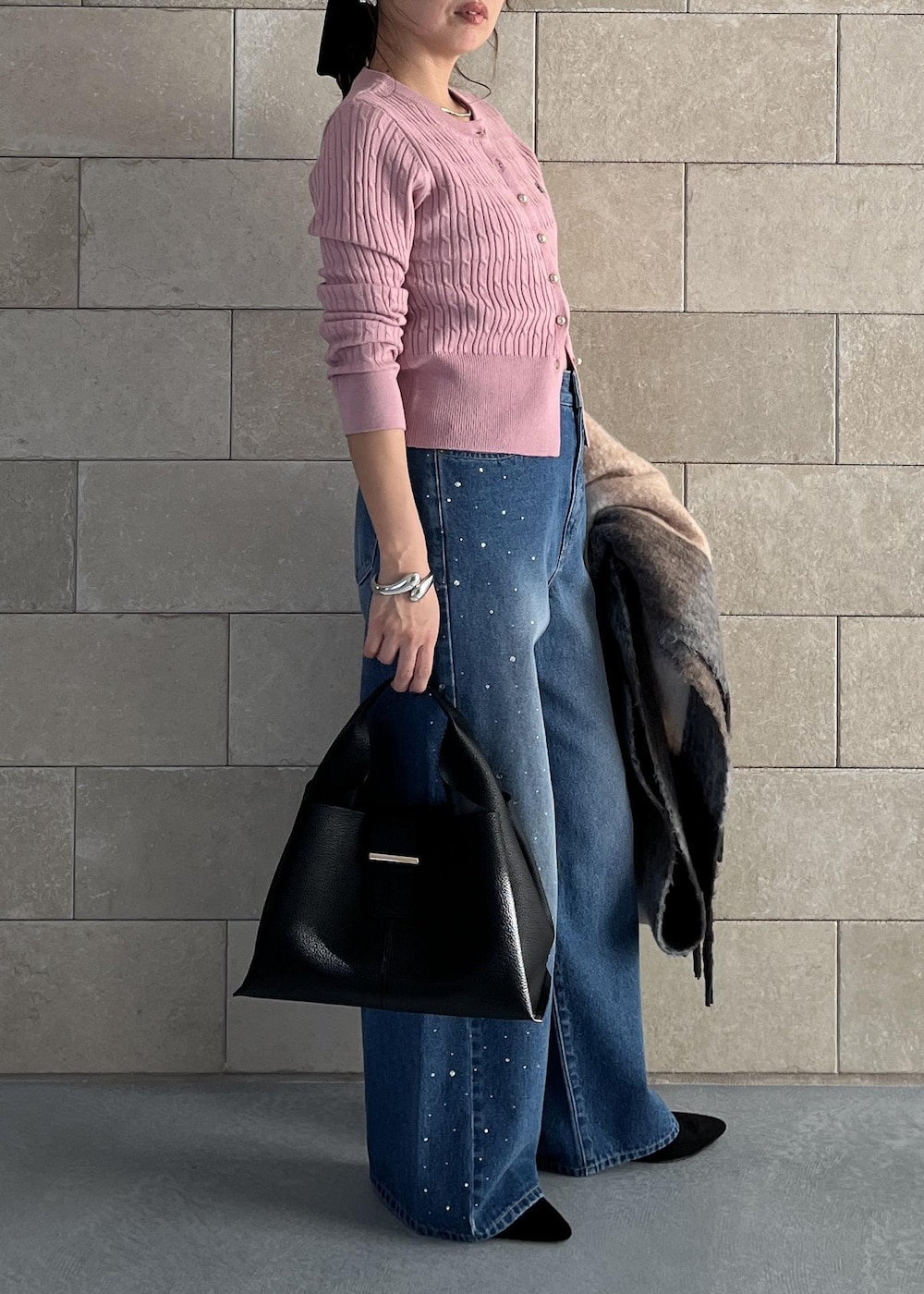 ブラック系のハンドバッグ、ピンク系のカーディガン/ボレロ、ブルー系のデニムパンツを着用したレディースの秋コーディネートの8枚目の写真
