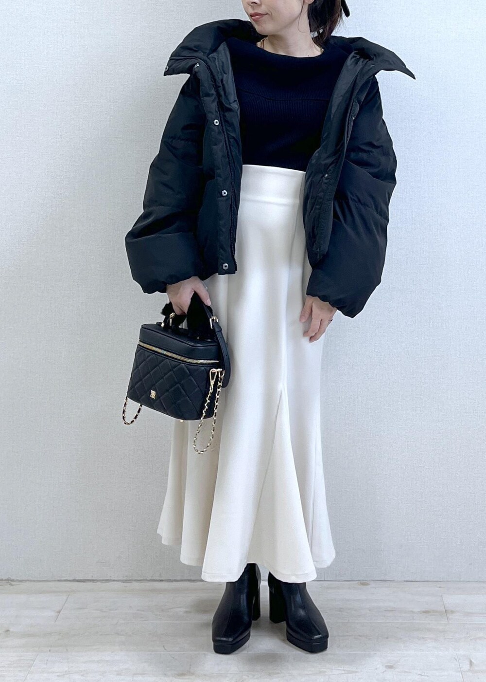 ブラック系のニット/セーター、ブラック系のダウンジャケット/コート、ブラック系のブーツを着用したレディースの冬コーディネートの8枚目の写真