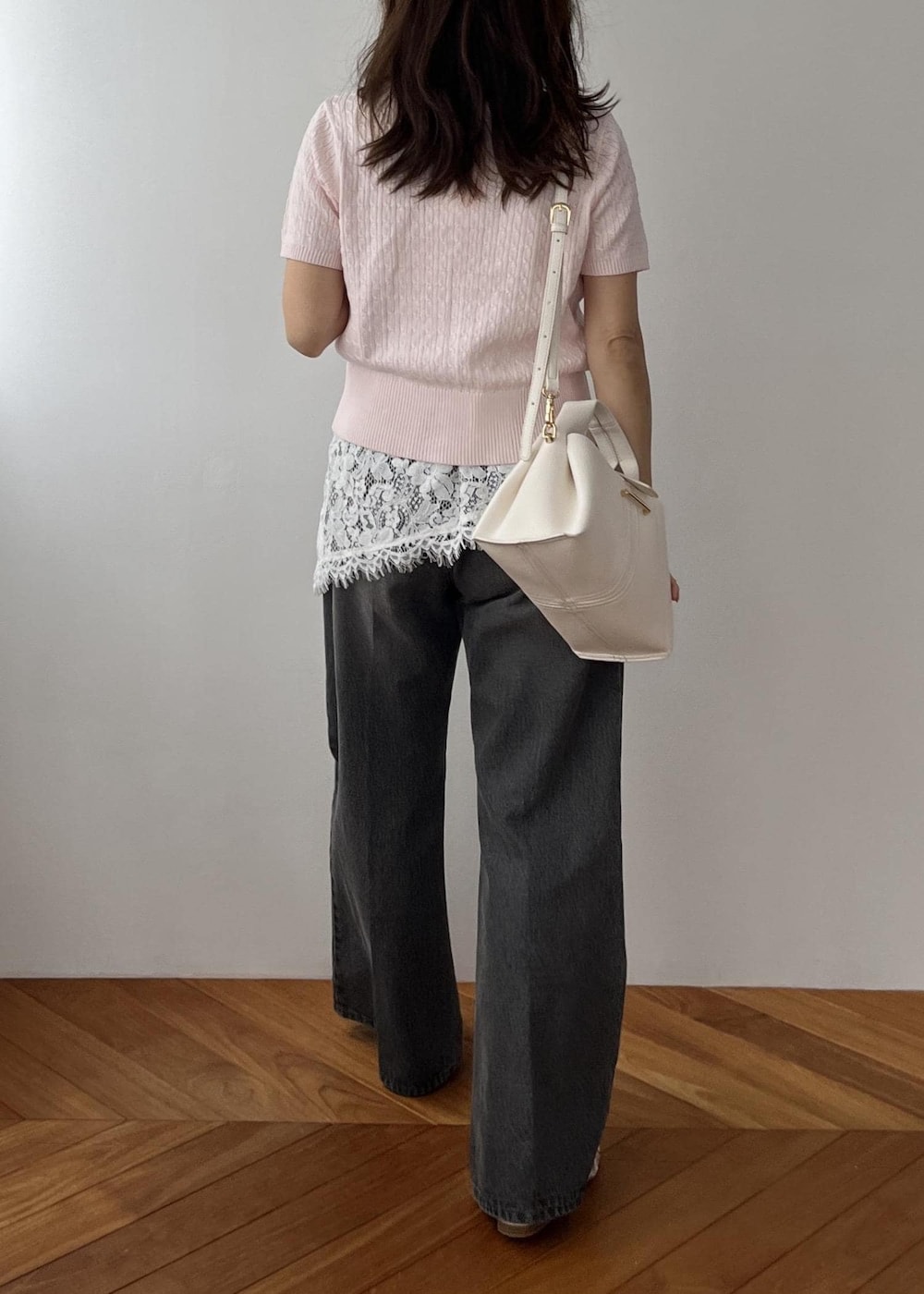 ホワイト系のキャミソール、ブラック系のデニムパンツ、ホワイト系のショルダーバッグを着用したレディースの春コーディネートの5枚目の写真