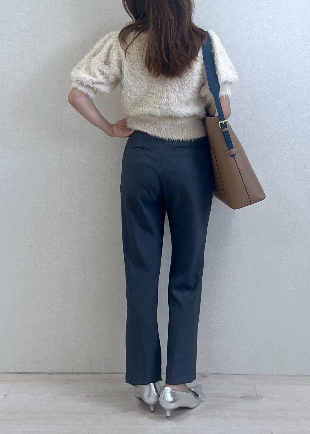 シルバー系のパンプス、イエロー系のショルダーバッグ、ホワイト系のニット/セーターを着用したレディースの秋コーディネートの4枚目の写真