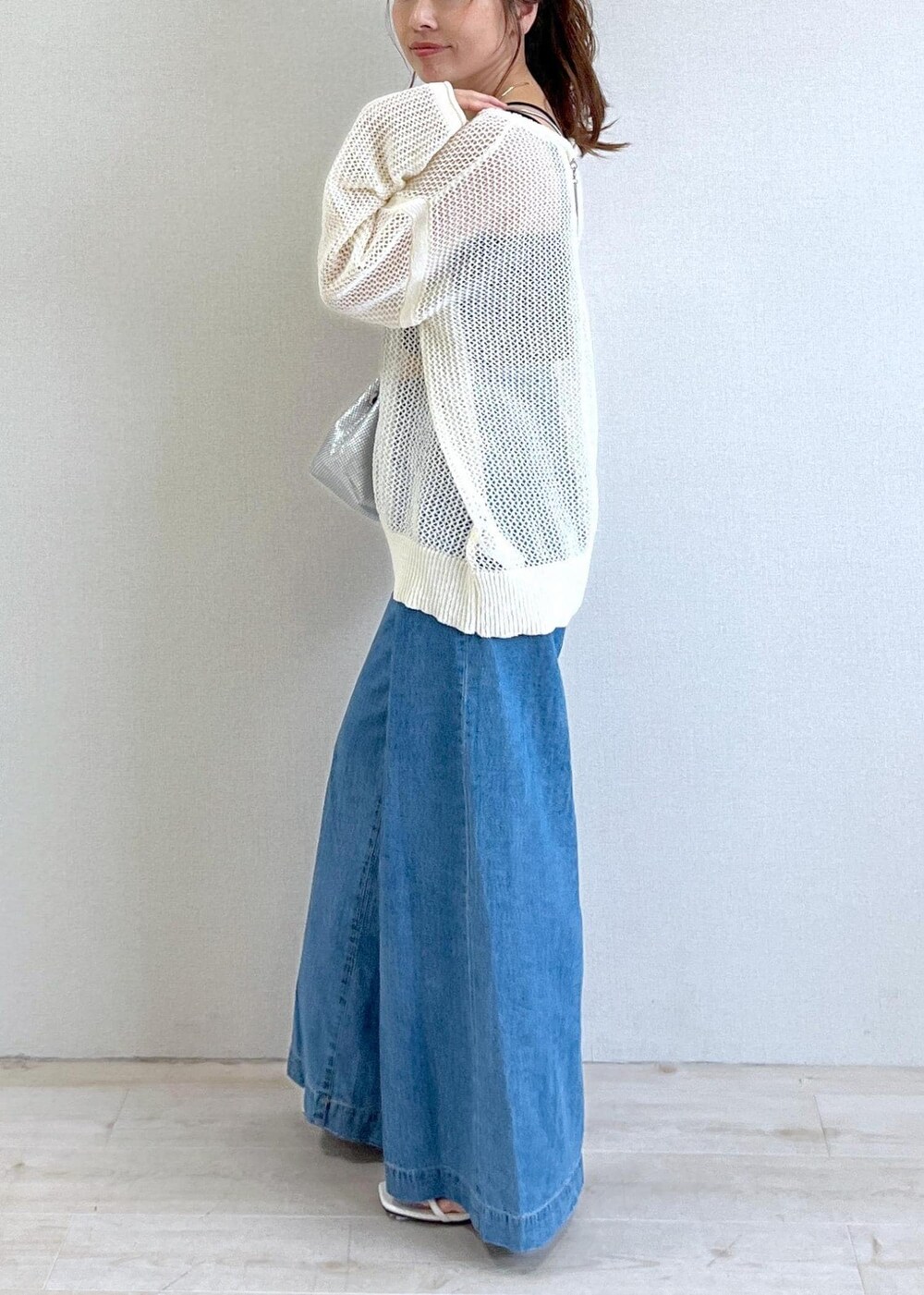 ホワイト系のサンダル、ブラック系のキャミソール、ブルー系のデニムパンツを着用したレディースの夏コーディネートの2枚目の写真