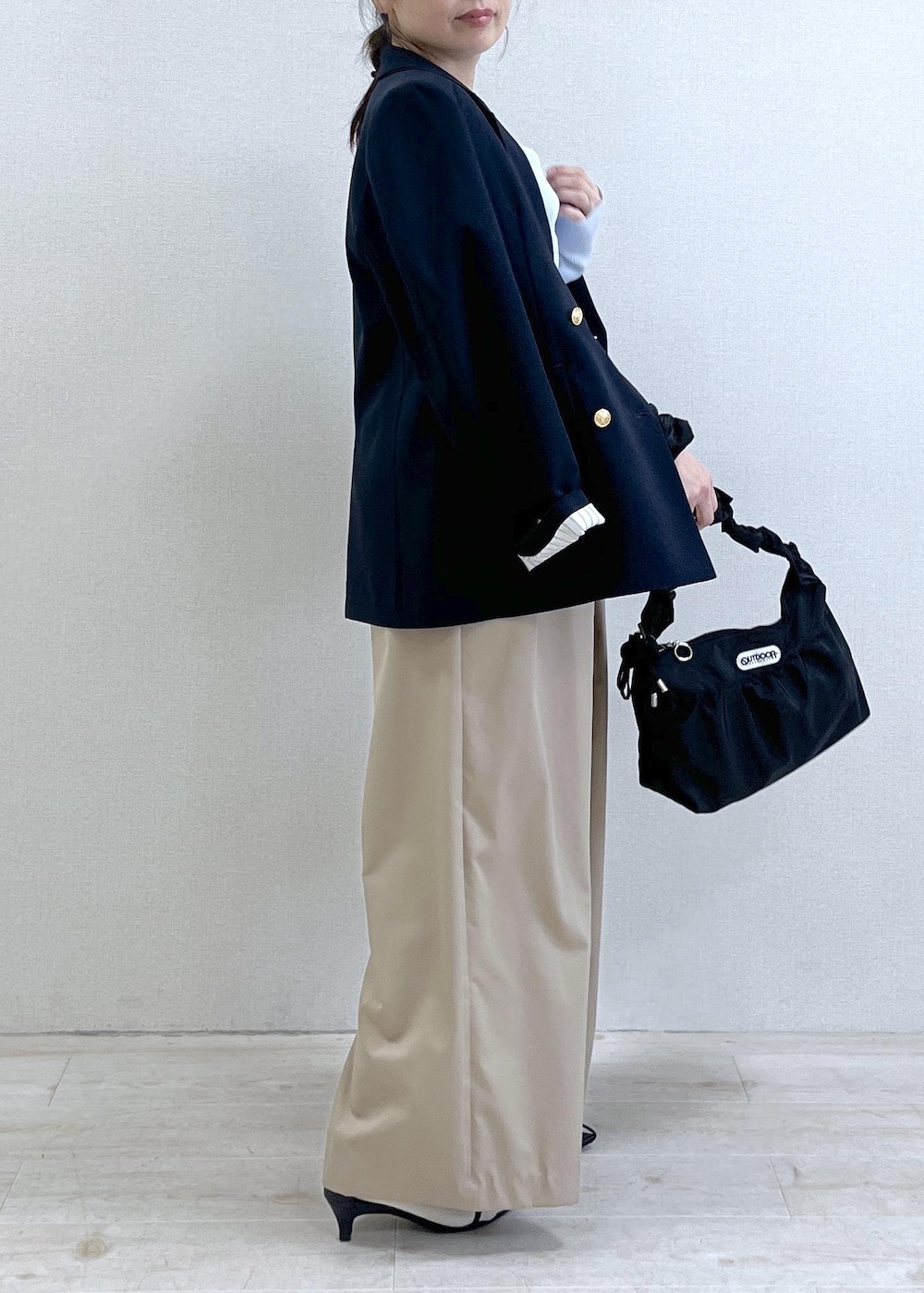 ブルー系のテーラードジャケット、ベージュ系のその他パンツ、ブラック系のショルダーバッグを着用したレディースの冬コーディネートの3枚目の写真