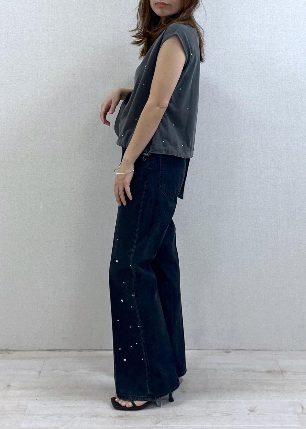 ブラック系のショルダーバッグ、ブラック系のサンダル、ブラック系のデニムパンツを着用したレディースの夏コーディネートの3枚目の写真