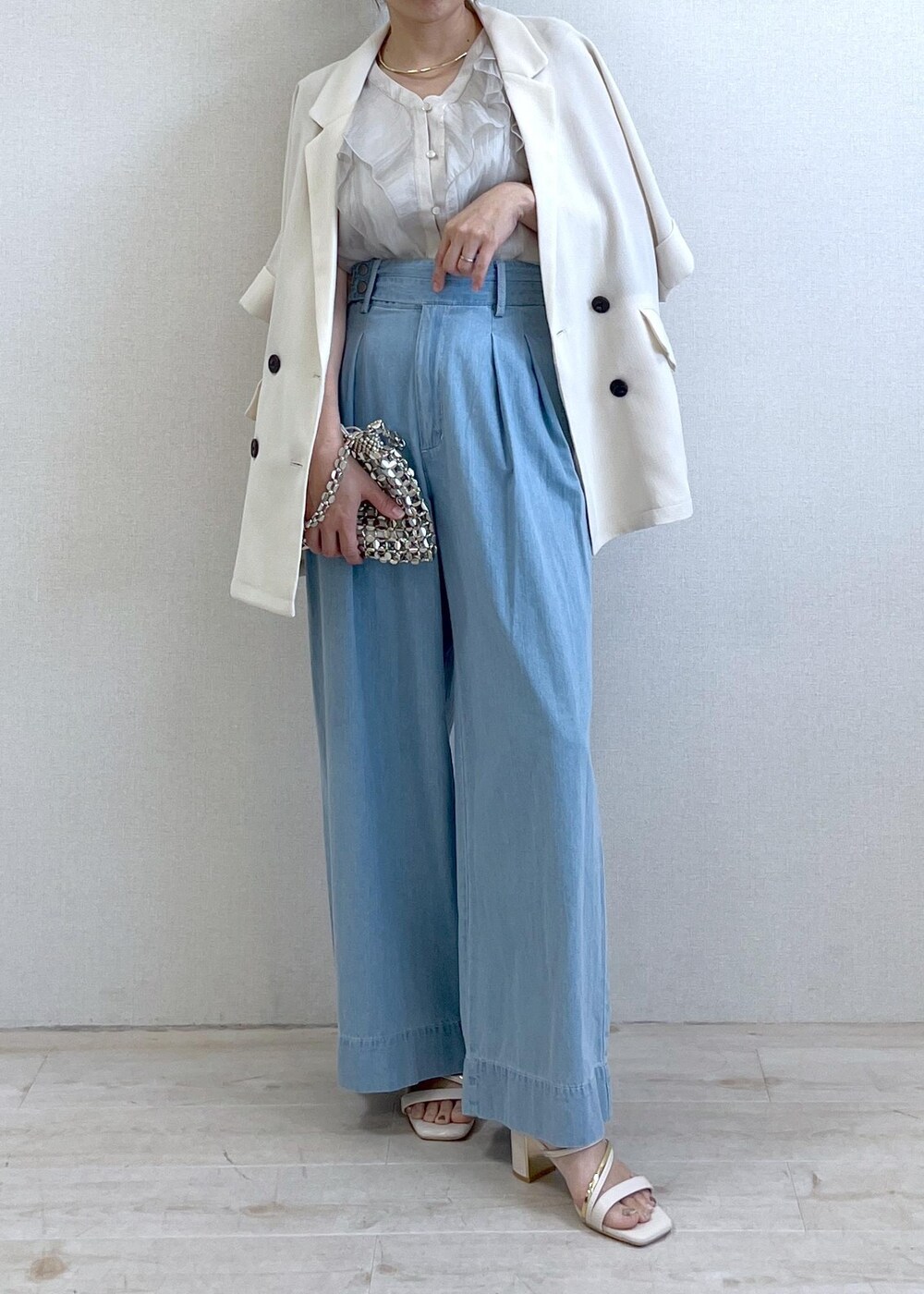 ホワイト系のサンダル、シルバー系のハンドバッグ、ブルー系のデニムパンツを着用したレディースの夏コーディネートの7枚目の写真