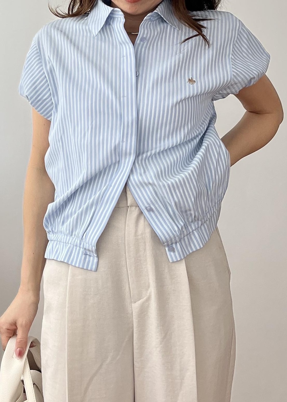 ホワイト系のその他パンツ、ホワイト系のショルダーバッグ、ホワイト系のサンダルを着用したレディースの春コーディネートの7枚目の写真