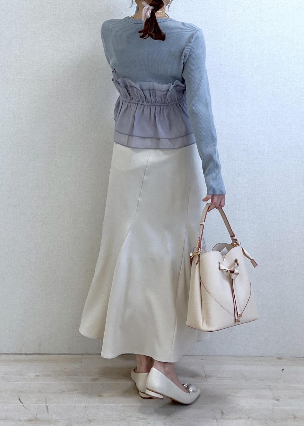 ベージュ系のショルダーバッグ、ホワイト系のバレエシューズ、ブルー系のニット/セーターを着用したレディースの春コーディネートの4枚目の写真