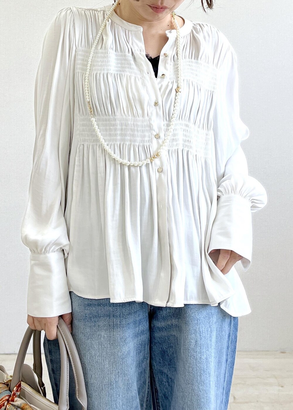 ブラック系のキャミソール、ブルー系のデニムパンツ、ブラック系のカーディガン/ボレロを着用したレディースの春コーディネートの10枚目の写真