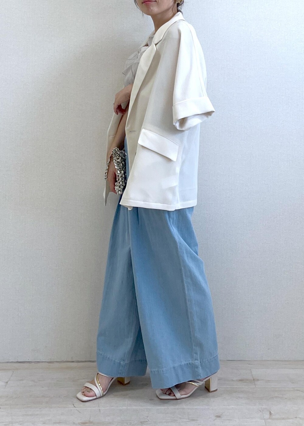 ホワイト系のサンダル、シルバー系のハンドバッグ、ブルー系のデニムパンツを着用したレディースの夏コーディネートの8枚目の写真