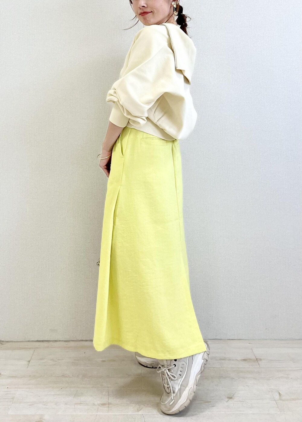 ホワイト系のキャミソール、イエロー系のスカート、ホワイト系のカーディガン/ボレロを着用したレディースの春コーディネートの2枚目の写真